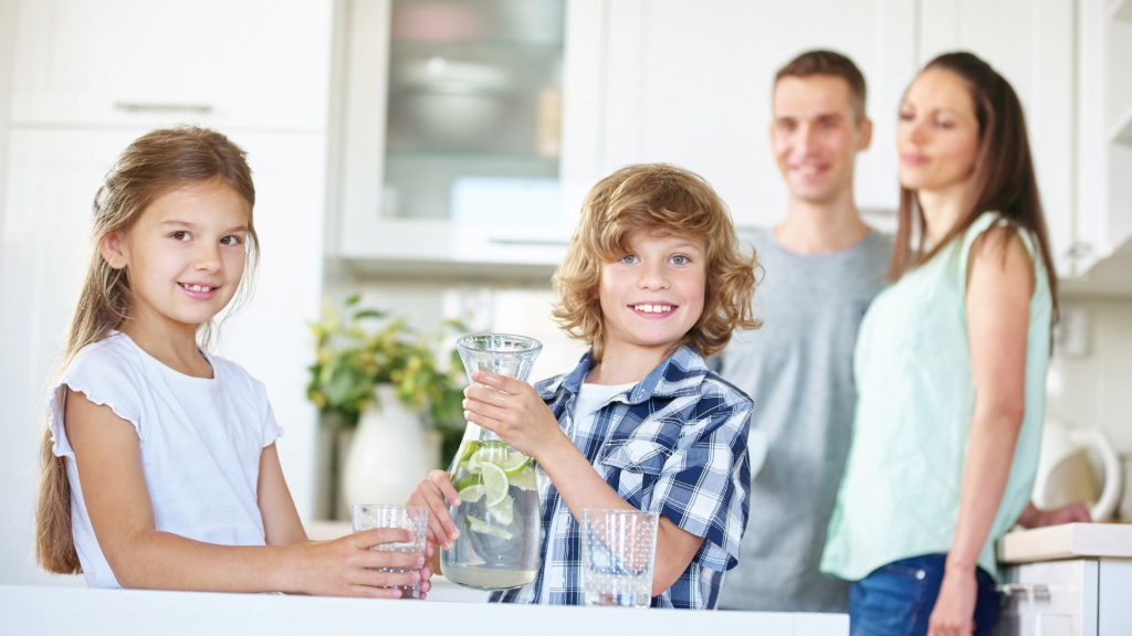 Família em casa com um jarro de água